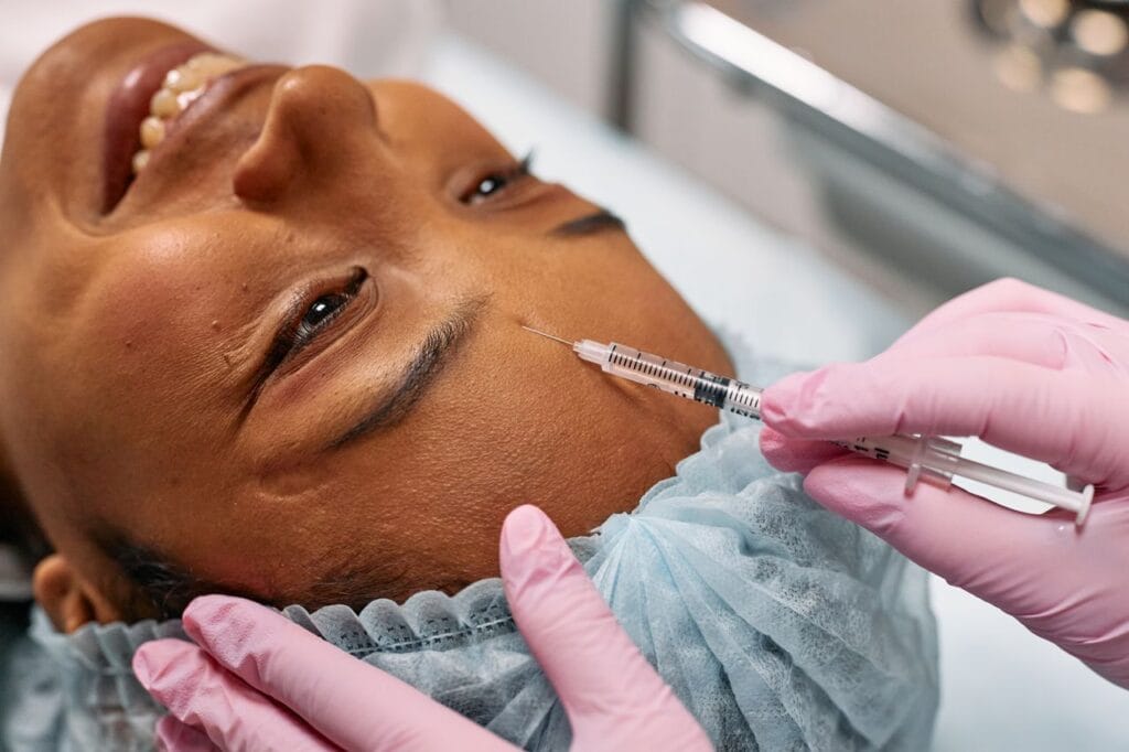 pexels-photo-7581577-7581577 Close-up of a woman receiving a cosmetic injection on her forehead in a clinical setting.